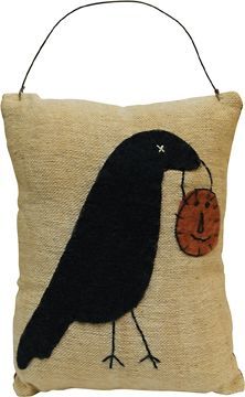 a pillow with a black bird on it and a pumpkin hanging from the back of it