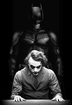 the dark knight movie poster with batman and joker in suit sitting at desk looking down