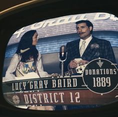 a television screen showing an image of two people on the stage with a microphone in front of them