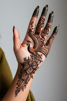 a woman's hand painted with henna and peacocks on her left palm