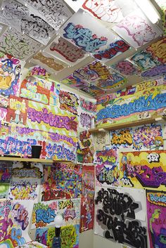 a room filled with lots of different colored graffiti on the walls and ceiling above it