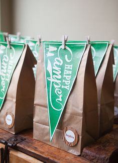 there are many bags on the table that have been decorated with green pennants and white lettering