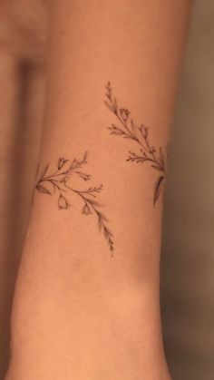 a woman's arm with a small branch tattoo on the left side of her body