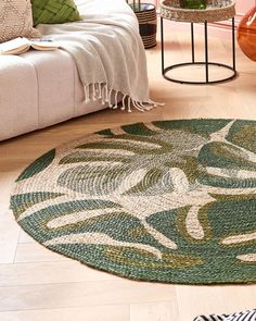 a green and white rug on the floor in a living room next to a couch