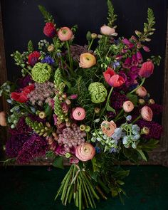 a vase filled with lots of different colored flowers