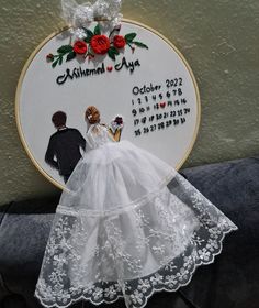 a wedding cake topper with a bride and groom on it, in front of a wall