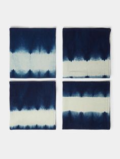 four blue and white napkins on top of each other