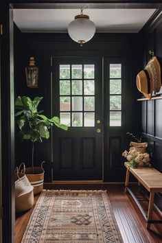 the entryway is decorated in black and features a large rug, potted plant, and wooden bench