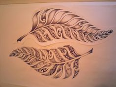 a drawing of two feathers with intricate designs