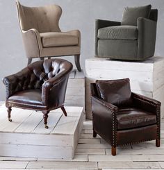 three leather chairs sitting next to each other in front of a gray wall and wooden floor