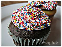 two chocolate cupcakes with sprinkles on top