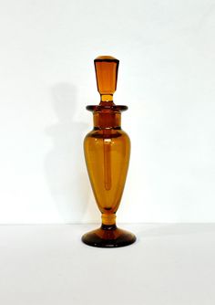 a brown glass vase sitting on top of a white table