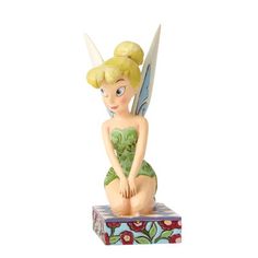 a figurine is sitting on top of a box with a toothbrush in it