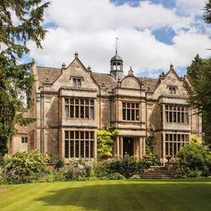 an old building with lots of windows and green grass