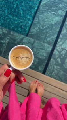 a cup of coffee with the words good morning written on it in front of a woman's feet