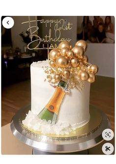 a birthday cake decorated with champagne and gold balloons