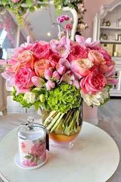 a vase filled with lots of pink flowers on top of a table