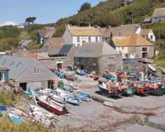 there are many small boats parked in the harbor next to each other on the shore