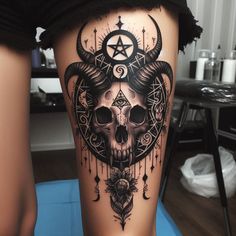 a woman's thigh with a skull and pentagramus tattoo on it