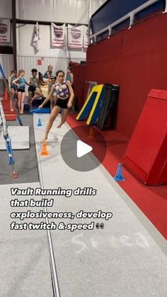 a group of people in a gym with one person jumping over an obstacle course and the other