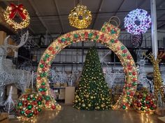 christmas lights and decorations are displayed in an indoor area with large archways, wreaths, and trees