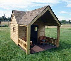 a small wooden shed with benches in the grass