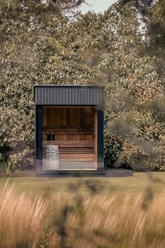 an outdoor sauna in the middle of some tall grass