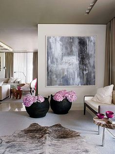 three different rooms with white walls and pink flowers in vases on the floor, one is