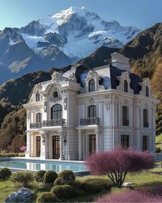 a large white house with a pool in front of it and mountains in the background