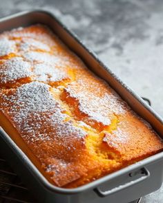 a cake in a pan with powdered sugar on top