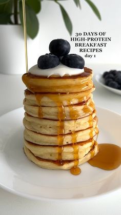 a stack of pancakes with syrup and blueberries on top