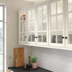 a kitchen with gray cabinets and white counter tops