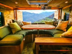 a living area with couches, table and television in an rv on the road