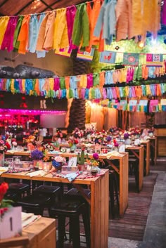 colorful streamers hang from the ceiling above tables in a restaurant decorated for a party