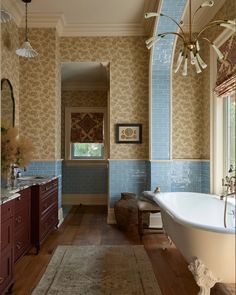 a bath room with a tub a sink and a rug on the floor in front of a window