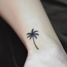 a small palm tree tattoo on the wrist