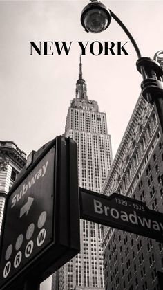 a black and white photo of the empire building in new york city, with broadway street signs