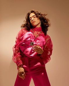 a woman in a pink outfit posing for a photo with her hands on her hips