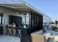 an outdoor bar and seating area on the roof of a building