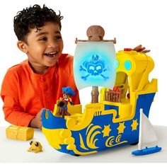 a young boy playing with a toy pirate ship