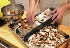 a person is grating mushrooms on a pan