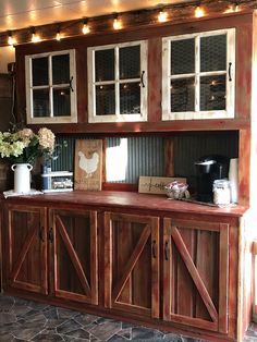 a kitchen area with wooden cabinets and lights on the wall above it, along with a coffee maker