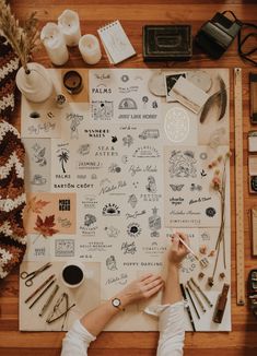 a person sitting at a table surrounded by crafting supplies and other things on it