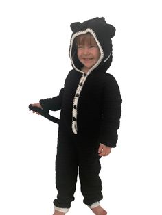 a young child wearing a black bear costume