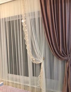 a bedroom with sheer curtains and pink bedspread