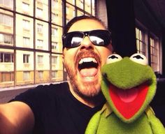 a man with sunglasses on taking a selfie with the muppet