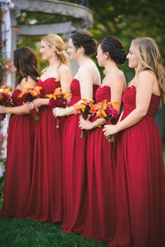 a group of women in red dresses standing next to each other