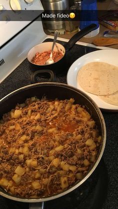 a pan filled with food sitting on top of a stove next to a plate and bowl