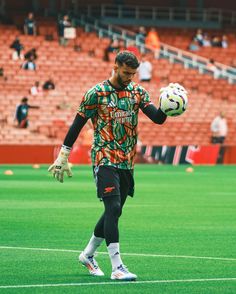 a man holding a soccer ball on top of a field