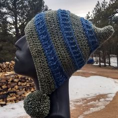 a mannequin head wearing a knitted hat with blue and green stripes on it